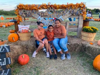 Three kids posting at a photo spot at the annual Cornerstone Baptist Pumpkin Patch